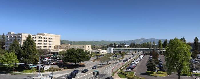 Outside of the hospital buildings showing the hospital, street, and parking lot